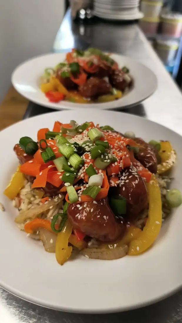 Bol de boulettes glacées au sésame avec carottes, oignons verts et riz aux légumes
